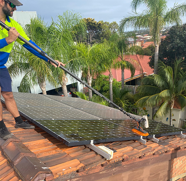 cleaning solar panels on a roof